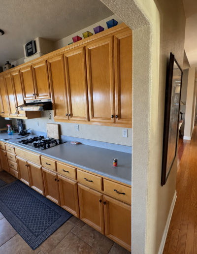 Kitchen before remodeling with natural wood cabinets, laminate countertops and an enclosed layout