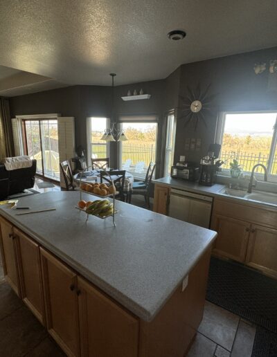 Kitchen and dining area before remodeling featuring an existing center island, wood cabinets and traditional floor plan
