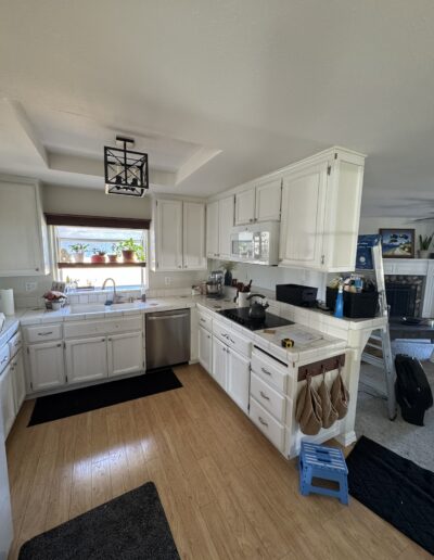 Kitchen before remodeling in Cameron Park, CA featuring white cabinets, tile countertops, wood flooring and a peninsula cooktop
