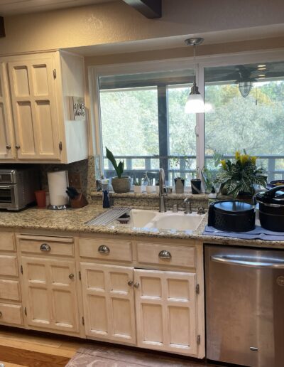Original kitchen sink area with distressed white cabinets and granite countertops before Cameron Park kitchen remodel