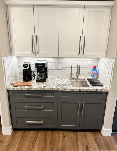 Custom coffee bar in Cameron Park kitchen featuring white shaker upper cabinets, gray base cabinets and stainless steel prep sink